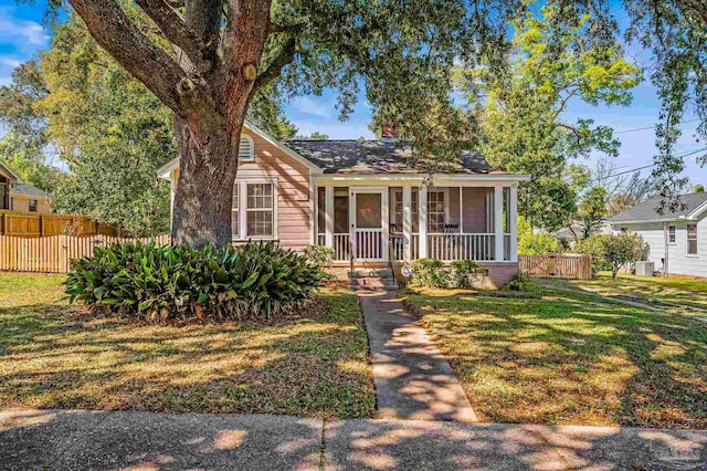 view of front of home featuring a sunroom, fence, and a front lawn