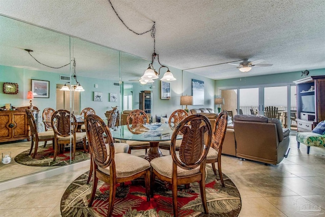 dining space featuring a ceiling fan, tile patterned flooring, visible vents, and a textured ceiling