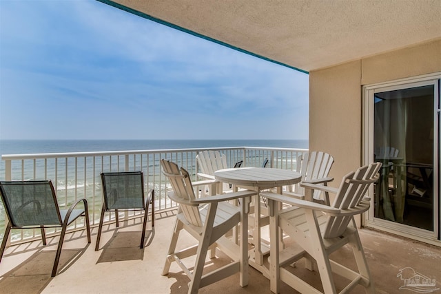 balcony with a water view and a view of the beach