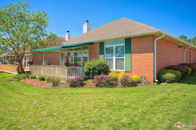 1424 Champions Green Dr, Gulf Breeze, FL 32563 - rear view of property featuring a yard, brick siding, a chimney, and a shingled roof