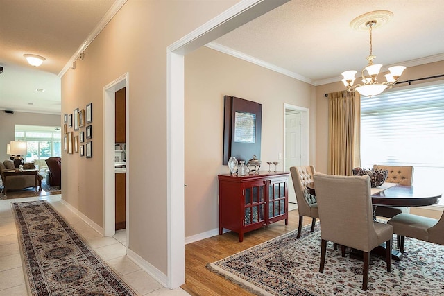 1424 Champions Green Dr, Gulf Breeze, FL 32563 - dining area with ornamental molding, light wood-style flooring, a notable chandelier, and baseboards