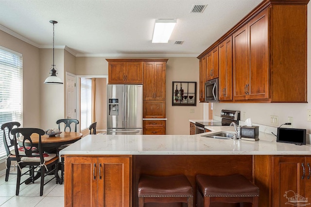 1424 Champions Green Dr, Gulf Breeze, FL 32563 - kitchen with visible vents, a wealth of natural light, appliances with stainless steel finishes, a peninsula, and brown cabinetry
