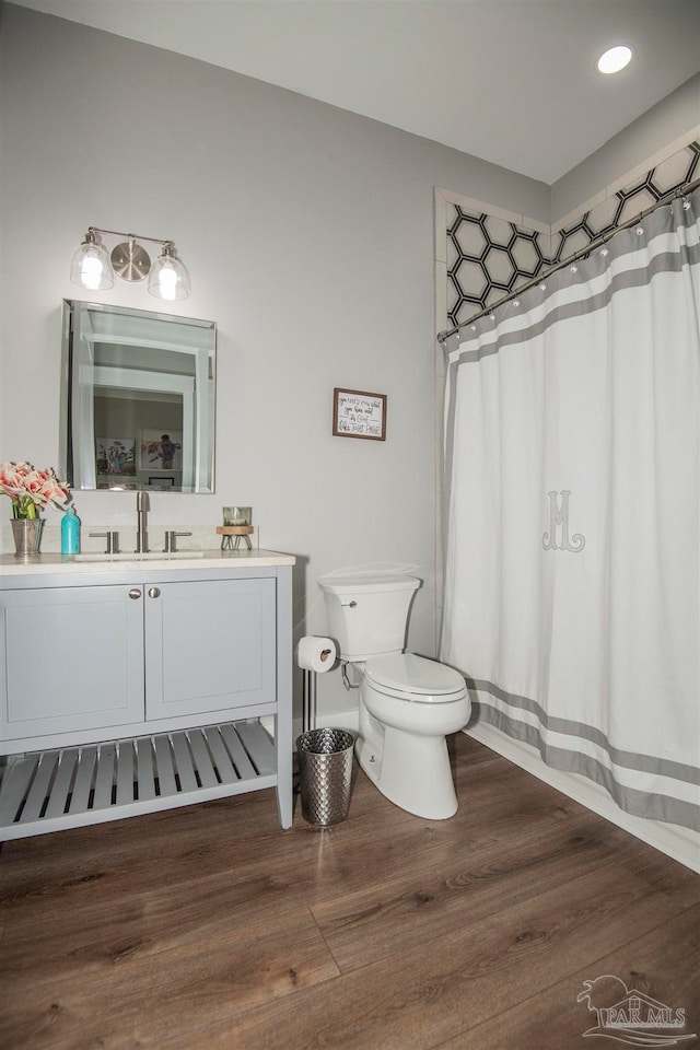 bathroom with hardwood / wood-style floors, vanity, and toilet