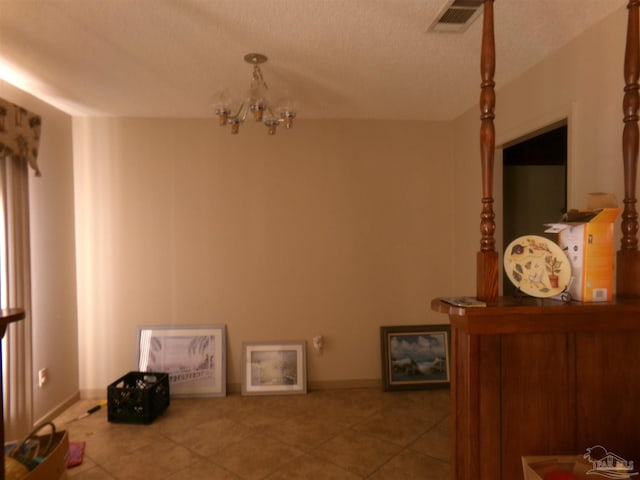 dining room featuring tile patterned flooring, a notable chandelier, and a textured ceiling