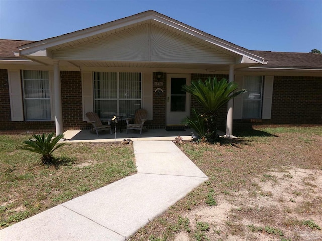 single story home featuring a front lawn and a patio