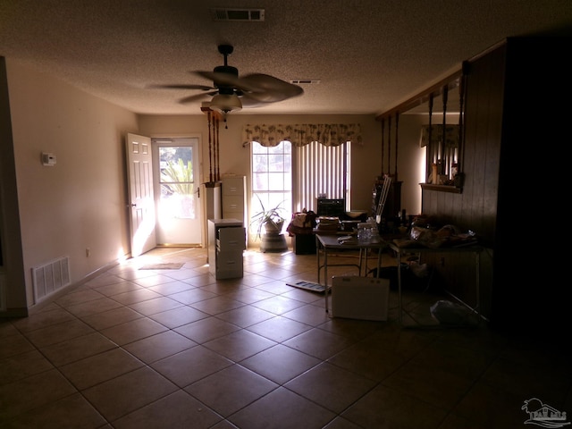 tiled living room with ceiling fan and a textured ceiling