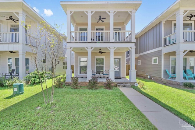 1121 W Romana St, Pensacola, FL 32502 - view of front of property with a ceiling fan, board and batten siding, a balcony, a front lawn, and covered porch