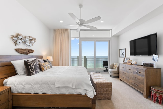 carpeted bedroom featuring expansive windows, access to outside, and ceiling fan