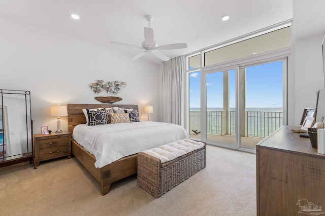 bedroom featuring a water view, access to outside, light colored carpet, and ceiling fan