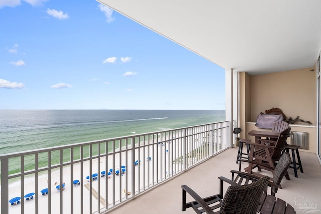 balcony featuring a water view and a beach view