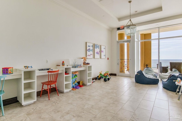 playroom with a raised ceiling, crown molding, light tile patterned flooring, and a chandelier