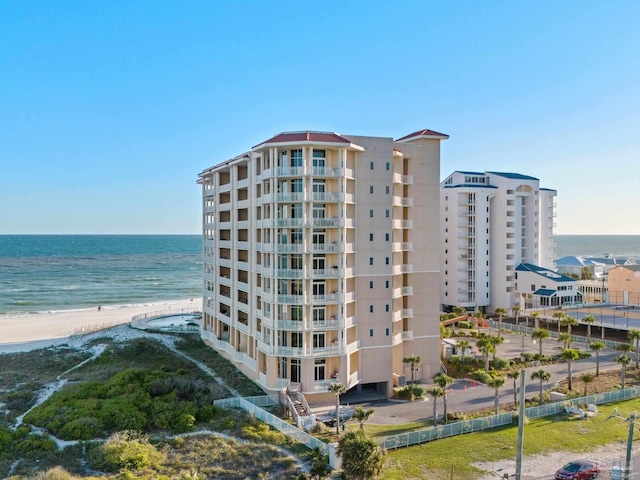 view of building exterior featuring a water view and a view of the beach