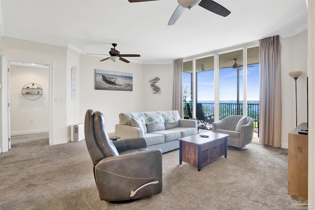 carpeted living room featuring expansive windows, crown molding, and ceiling fan