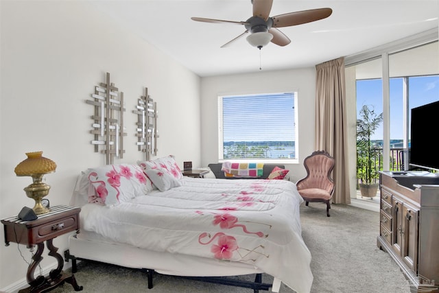 carpeted bedroom featuring multiple windows, access to outside, and ceiling fan