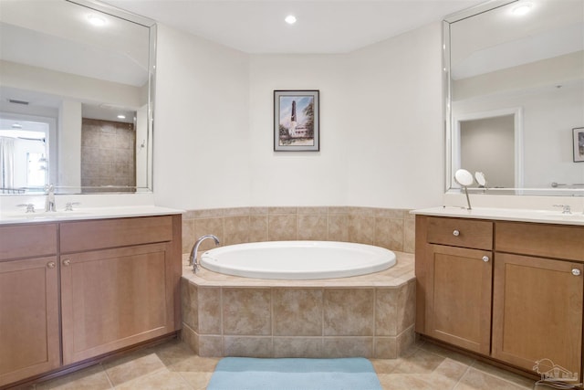 bathroom featuring tile patterned floors, vanity, and tiled tub