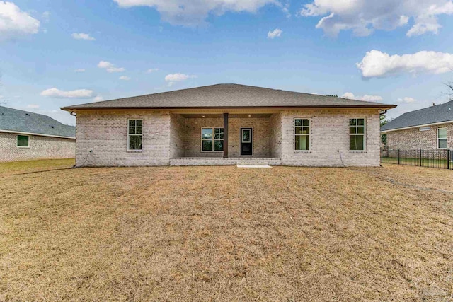 back of property featuring brick siding, fence, a patio, and a yard