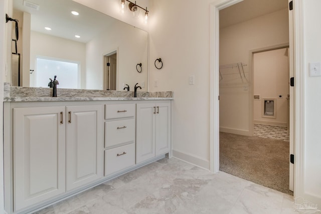 bathroom with double vanity, visible vents, a spacious closet, a sink, and recessed lighting