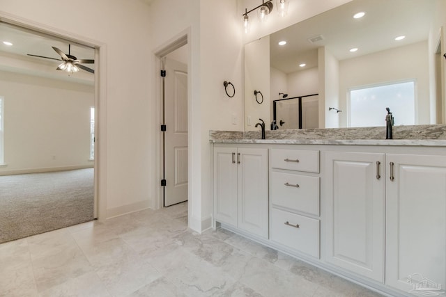 bathroom with double vanity, a stall shower, ceiling fan, a sink, and recessed lighting