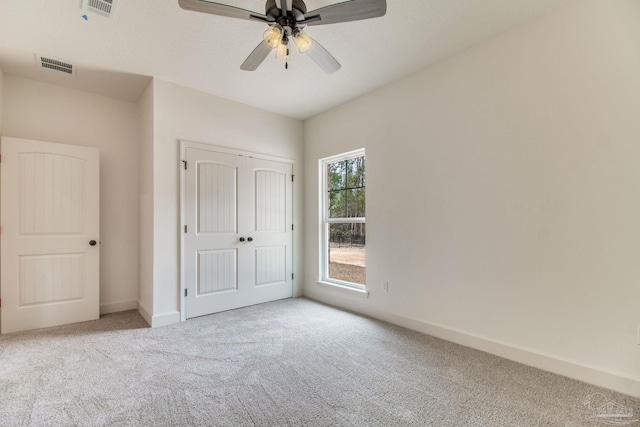 unfurnished bedroom with carpet floors, a closet, visible vents, and baseboards