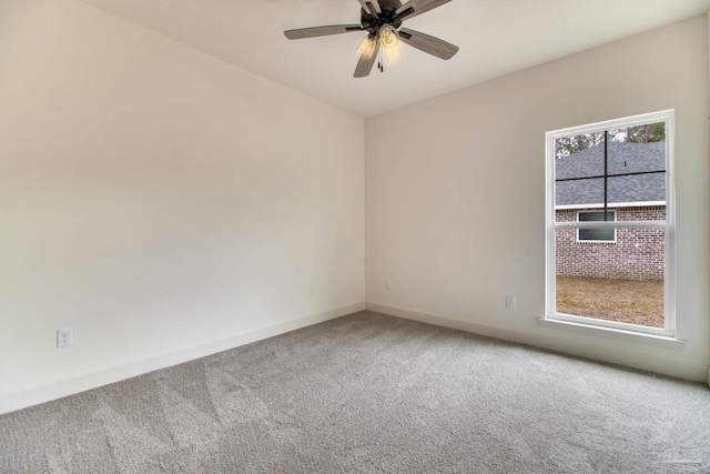 carpeted empty room with a ceiling fan and baseboards