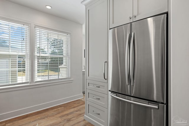 kitchen featuring baseboards, freestanding refrigerator, light wood-type flooring, white cabinetry, and recessed lighting