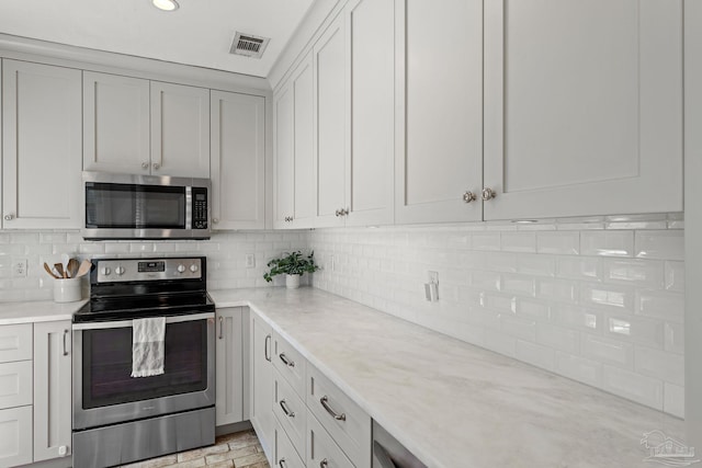 kitchen featuring stainless steel appliances, recessed lighting, visible vents, and decorative backsplash