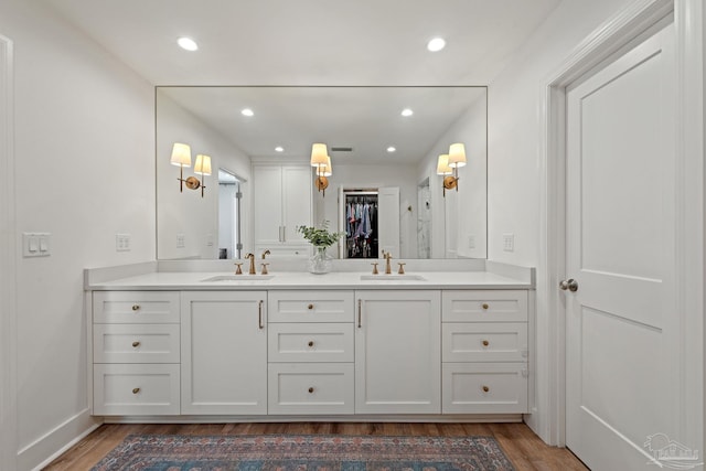 full bath featuring wood finished floors, a sink, and double vanity