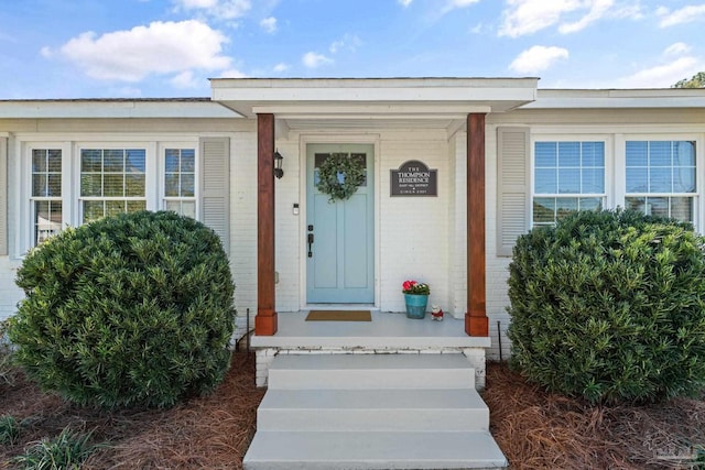 view of exterior entry with brick siding