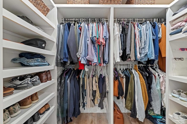 walk in closet with wood finished floors