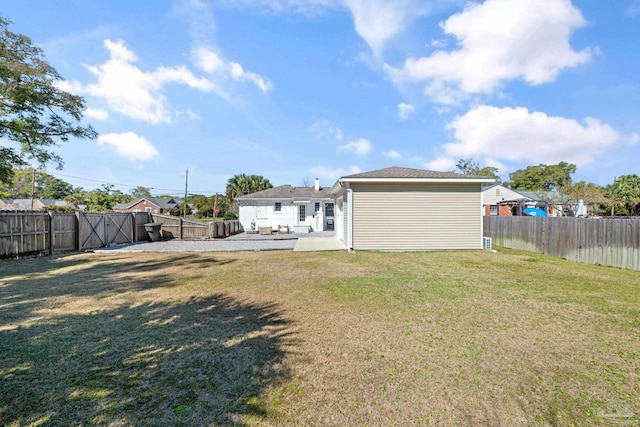 rear view of property with a yard, a patio, and a fenced backyard