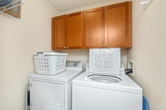 washroom featuring cabinet space and independent washer and dryer