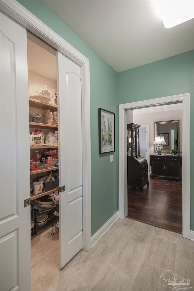 hallway with light wood-style flooring and baseboards