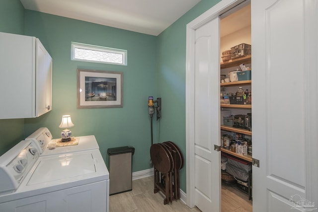 washroom with light wood-style flooring, washing machine and clothes dryer, cabinet space, and baseboards