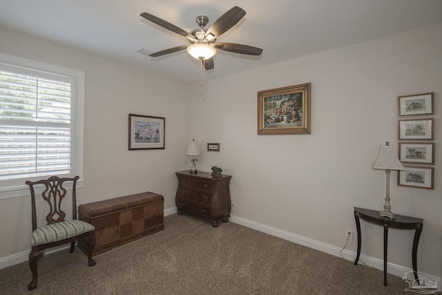 sitting room featuring ceiling fan, carpet floors, and baseboards