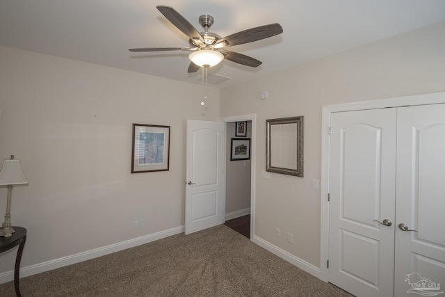 unfurnished bedroom with ceiling fan, a closet, dark carpet, and baseboards