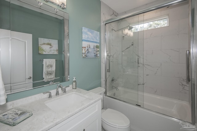 full bath featuring combined bath / shower with glass door, vanity, and toilet