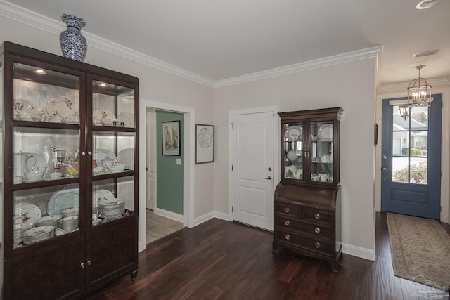 entryway featuring baseboards, crown molding, dark wood-style flooring, and a notable chandelier