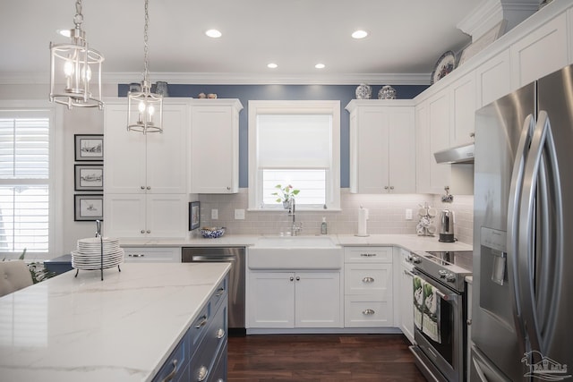 kitchen with under cabinet range hood, stainless steel appliances, a sink, white cabinets, and pendant lighting