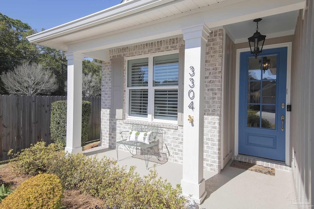 entrance to property with brick siding and fence