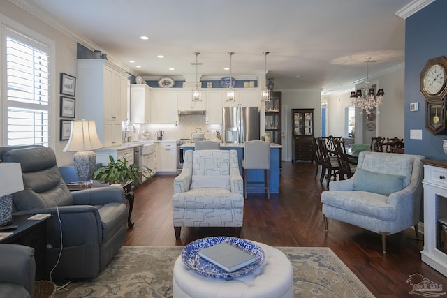 living room featuring dark wood-style floors, a chandelier, crown molding, and recessed lighting