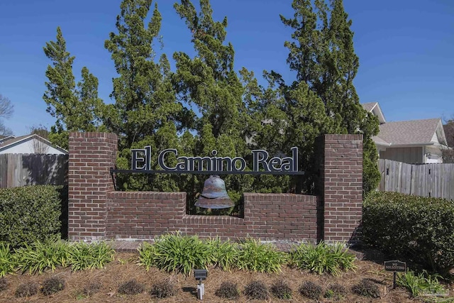 community / neighborhood sign featuring fence