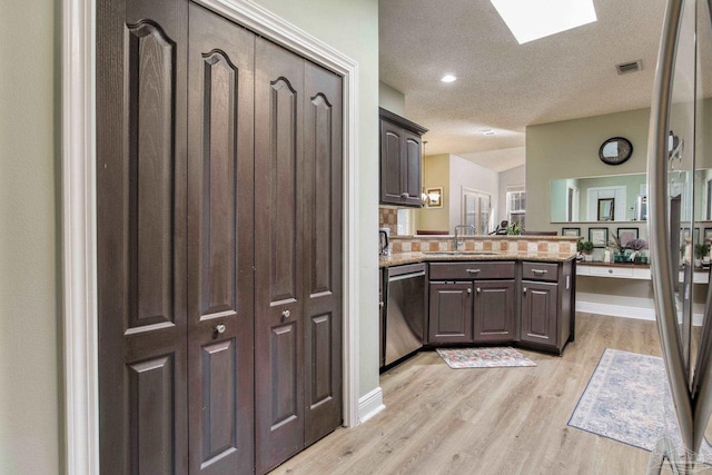 9348 Bell Ridge Dr, Pensacola, FL 32526 - kitchen featuring visible vents, stainless steel dishwasher, a sink, light wood finished floors, and a peninsula