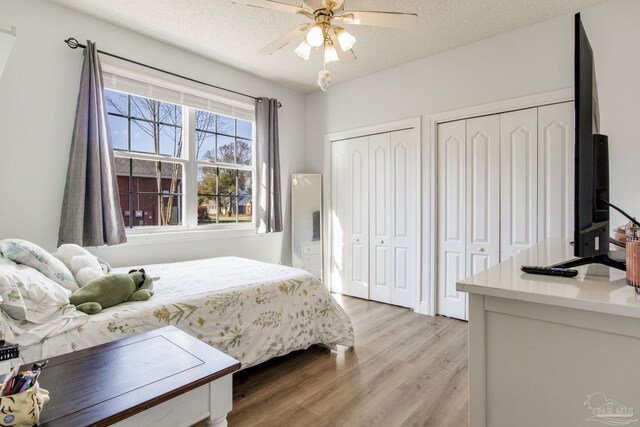 9348 Bell Ridge Dr, Pensacola, FL 32526 - bedroom featuring multiple closets, light wood finished floors, and ceiling fan