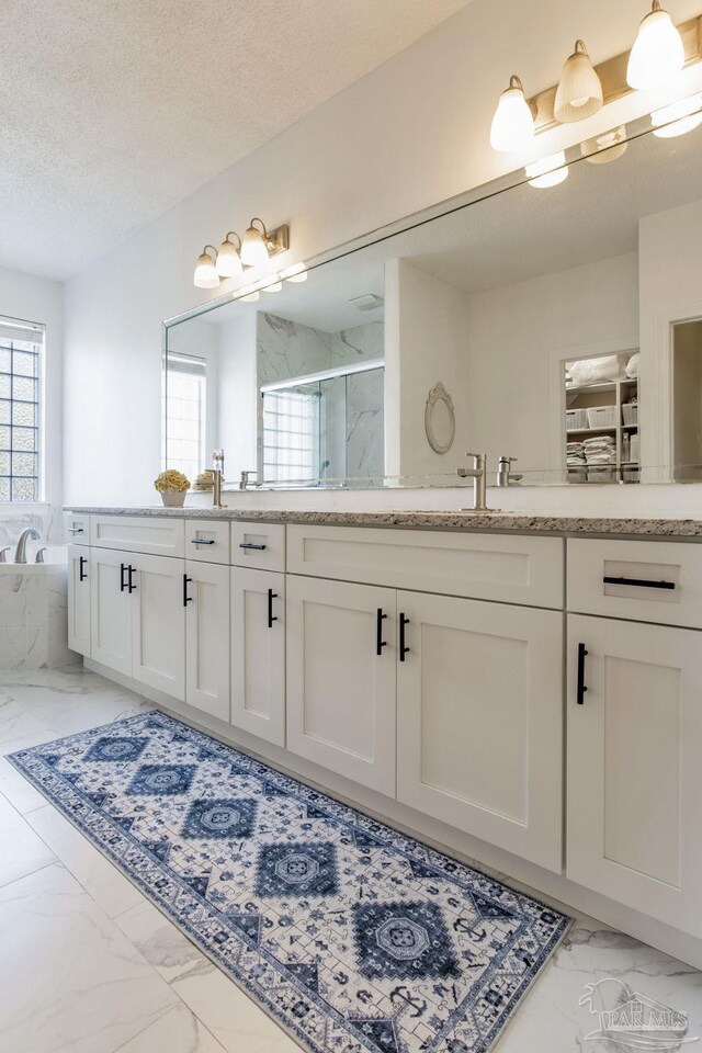 9348 Bell Ridge Dr, Pensacola, FL 32526 - bathroom featuring vanity, a textured ceiling, a marble finish shower, marble finish floor, and a garden tub