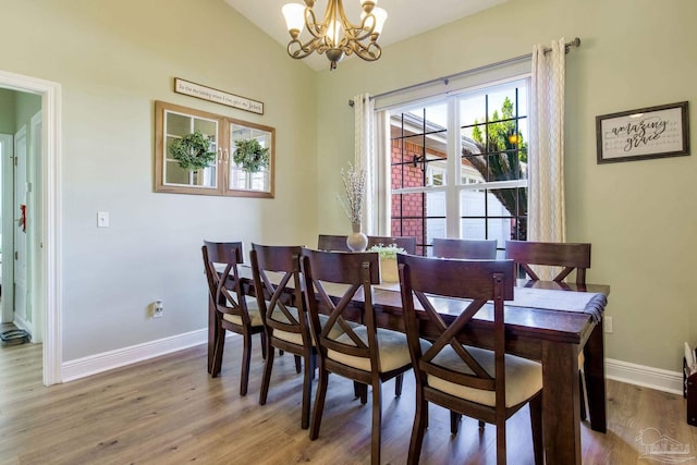 9348 Bell Ridge Dr, Pensacola, FL 32526 - dining room featuring baseboards, wood finished floors, a chandelier, and vaulted ceiling