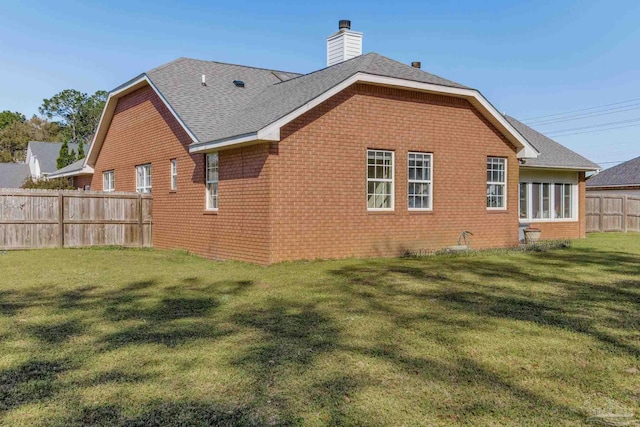 9348 Bell Ridge Dr, Pensacola, FL 32526 - rear view of house with a chimney, brick siding, fence, a yard, and a shingled roof