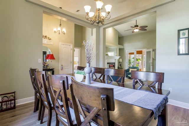 9348 Bell Ridge Dr, Pensacola, FL 32526 - dining room with baseboards, a towering ceiling, ceiling fan with notable chandelier, and wood finished floors