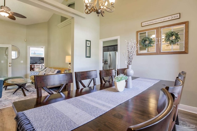 9348 Bell Ridge Dr, Pensacola, FL 32526 - dining space featuring high vaulted ceiling, baseboards, ceiling fan with notable chandelier, and wood finished floors