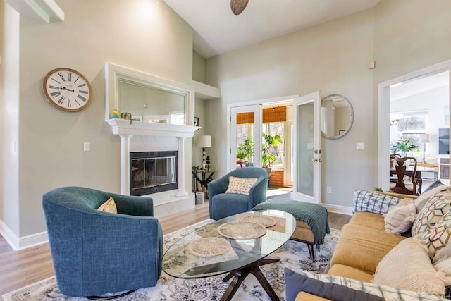 9348 Bell Ridge Dr, Pensacola, FL 32526 - living room featuring light wood-style floors, baseboards, a premium fireplace, and a towering ceiling