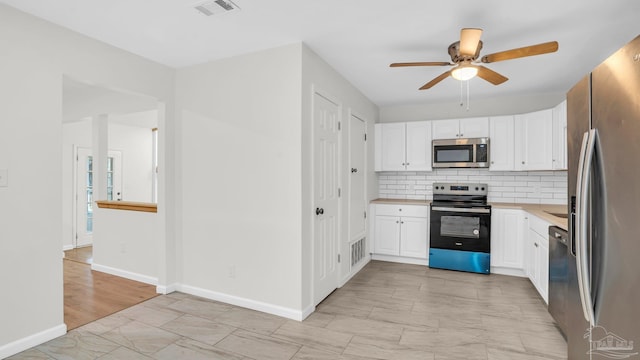 kitchen featuring decorative backsplash, white cabinetry, ceiling fan, and stainless steel appliances